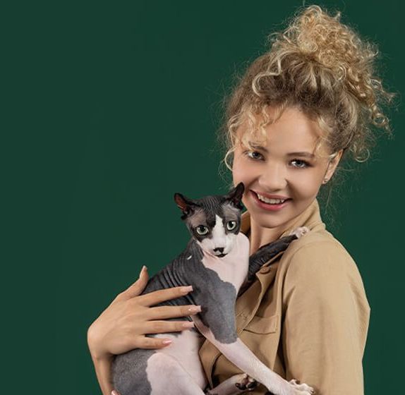 Девушка с кошкой породы сфинкс на руках
